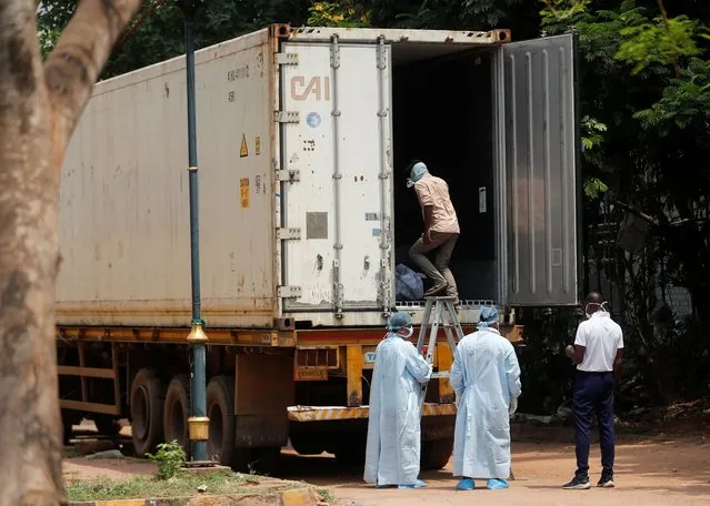 A man enters a deep freezer truck filled with dead bodies to try and identify a family member killed after a multiple train collision in Balasore, at a hospital in Bhubaneswar in the eastern state of Odisha, India on June 6, 2023. (Photo by Francis Mascarenhas/Reuters)
