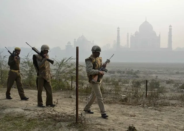 Indian security personnel patrol on the rear side of the historic Taj Mahal, on a foggy winter day in the northern Indian city of Agra, January 17, 2015. (Photo by Brijesh Singh/Reuters)