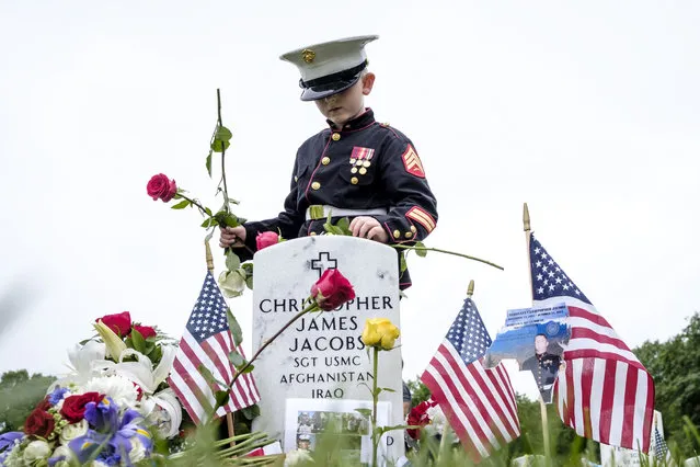 On Memorial Day, Christian Jacobs, 7, of Hertford, NC, tends the gravesite of his father, Marine Sgt. Christopher Jacobs, in Section 60 at Arlington National Cemetery in Arlington, Virginia, USA, on 28 May 2018. Section 60, is the burial ground in the cemetery where military personnel killed in the Global War on Terror since 2001 are interred. (Photo by Pete Marovich/EPA/EFE)