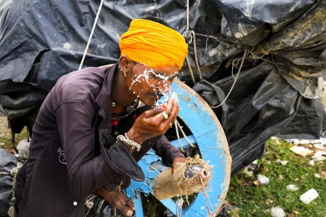 A man splashes water on his face to cool himself on a hot summer afternoon in Lalitpur district in northern Uttar Pradesh state, India, Sunday, June 18, 2023. (Photo by Rajesh Kumar Singh/AP Photo)