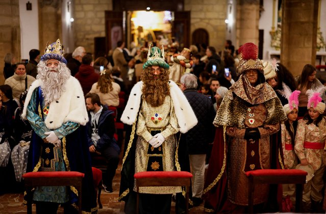 Juan Miguel Aguilar, 49, a local journalist, Diego Sanchez, 37, a local real estate agent, and Angel Ballesteros, 39, a local tourism businessman, dressed up as Melchior, Gaspar and Balthazar, the Three Wise Men, worship a statue of Christ placed on an altar inside a church, as they tour the city centre visiting churches, ahead of the Epiphany parade, in Ronda, Spain on January 4, 2025. (Photo by Jon Nazca/Reuters)