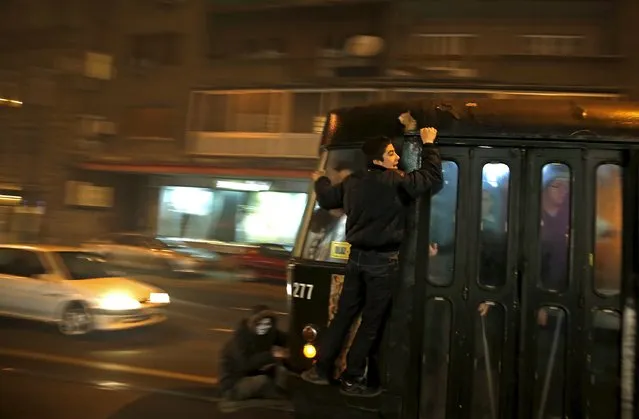 Youths cling to the side of a tram as smog blankets Sarajevo, Bosnia and Herzegovina, December 21, 2015. With severe air pollution affecting the city nestled among the mountains, the authorities have declared the first level of preparedness, advising the segment of the population that is at health risk to reduce movement in the mornings and evenings, appealing to drivers to use motor vehicles less and ordering heating utilities to lower the emission of harmful gases. (Photo by Dado Ruvic/Reuters)