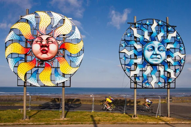 Sunny start to the day at the coast as Sun burst installations, part of the Illuminations spectacular appear on the section of the promenade as local residents, cyclists and tourists enjoy the early morning sun in Blackpool, Lancashire, UK on July 15, 2018. Blackpool Illuminations is an annual lights festival, founded in 1879 and held each autumn in the British seaside resort of Blackpool on the Fylde Coast. (Photo by Media World Images/Alamy Live News)