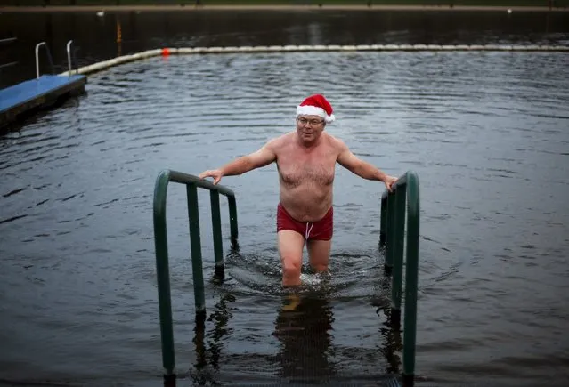 A swimmer emerges after taking a dip in the Serpentine River before the annual Christmas Day Peter Pan Cup handicap race in Hyde Park, London, December 25, 2015. (Photo by Andrew Winning/Reuters)