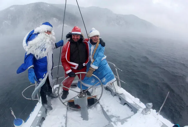 Members of the “Skipper” yacht club dressed as Santa Claus, its Russian equivalent Ded Moroz and his granddaughter Snegurochka (Snow Maiden) sail a yacht along the Yenisei River while marking the end of the sailboat season, with the air temperature at about minus 21 degrees Celsius (minus 5.8 degrees Fahrenheit), outside the Siberian city of Krasnoyarsk, Russia, November 21, 2016. (Photo by Ilya Naymushin/Reuters)