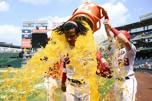 Washington Nationals' CJ Abrams, center, is doused by teammate Lane Thomas (28) after a baseball game against the Colorado Rockies, Wednesday, July 26, 2023, in Washington. Abrams hit a walk-off single to score a run to win the game. The Nationals won 5-4. (Photo by Nick Wass/AP Photo)
