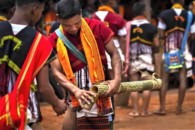 A Tiwa tribal man in traditional attire pours rice beer to serve participants during Wanchuwa festival in Singlangkunchi village, India, Wednesday, July 19, 2023. Wanchuwa festival, marked once every five years, is celebrated for a good harvest and the welfare of the people. (Photo by Anupam Nath/AP Photo)