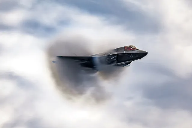 Stunning images capture a Royal Air Force fighter jet developing a vapor cone as it travels as incredible speed in the last decade of July 2023. The Lockheed Martin F-35B Lightning, operated from the HMS Queen Elizabeth as part of their Aviation Integration Period, created the visible cloud which is the result of condensed water forming around the surfaces of an object travelling at transonic speeds. It is often thought to be a result of the aircraft travelling at speeds greater than the speed of sound, but these cones actually form as a result of different regions around the aircraft creating airflow that travels at either subsonic or supersonic speeds. Something that adds to the affect is the aircrafts height, lower down air is denser, creates more drag which lends itself well to the creation of these cones. (Photo by Royal Air Force/Capture Media Agency)