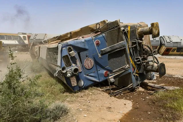 A derailed locomotive is pictured at the scene of a train accident near Msaken, about 150 kilometres (95 miles) south of the capital in eastern Tunisia, on June 21, 2023. Two people were killed and 34 injured when an overnight passenger train careered off the tracks and overturned, the state-owned SNCFT rail company said. The accident occurred shortly after midnight (2300 GMT), leaving the driver and a passenger killed while 34 other passengers were injured, according to the SNCFT. (Photo by Bechir Taieb/AFP Photo)