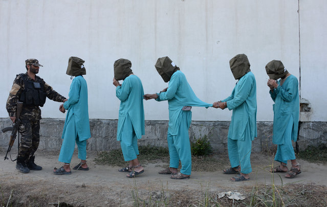 Suspected Islamic State (IS) and Taliban militants are brought before media during a press conference in Jalalabad on December 6, 2016. Afghan National Directorate Security (NDS) forces arrested three suspected Islamic State (IS) fighters and eight Taliban insurgents during an operation in different part of Jalalabad city, officials said. (Photo by Noorullah Shirzada/AFP Photo)