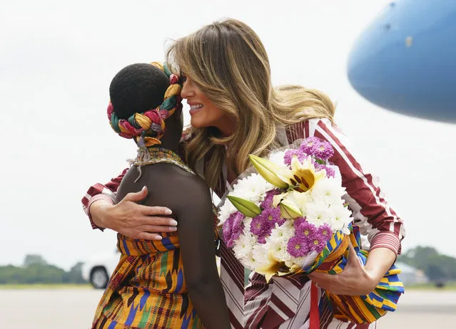 First lady Melania Trump embraces flower girl Lillian Naa Adai Sai, 8, as she receives flowers apon arrives at Kotoka International Airport in Accra, Ghana, Tuesday, October 2, 2018. (Photo by Carolyn Kaster/AP Photo)