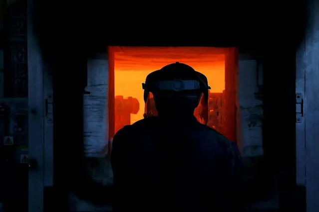 Worker Thomas O'Donoghue stands at an oven during the production of the Rolls-Royce mascots. (Photo by Stefan Wermuth/Reuters)