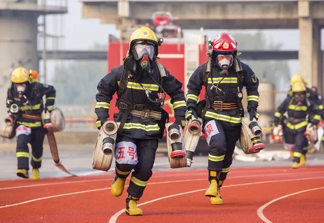 Firefighters take part in an emergency rescue competition on October 24, 2018 in Taizhou, Jiangsu Province of China. Firefighters from 19 emergency rescue teams in Taizhou participated in the competition with an aim to improve their emergency response and rescue ability on Wednesday. (Photo by VCG/VCG via Getty Images)