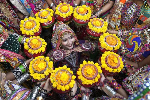 Indians in traditional attire pose for the media as they practice the Garba, a traditional dance of Gujarat state, ahead of Navratri festival in Ahmedabad, India, Monday, October 9, 2023. The Hindu festival of Navratri, or nine nights, will begin on October 15. (Photo by Ajit Solanki/AP Photo)