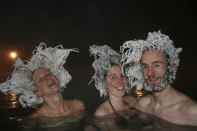 Bathers (L-R) Fanny Caritte,  Milena Georgeault and Maxime Goyou Beauchamps of France show off their frozen hair while bathing in a 40 degree Celsius (104 Fahrenheit) pool in air temperatures of -30 C (-22 F) at Takhini Hot Springs in Whitehorse, Yukon in this handout photo taken February 9, 2015. The hot springs announced on March 2 that the group had won the hot springs' 2015 International Hair Freezing Contest. (Photo by Fanny Caritte/Reuters)