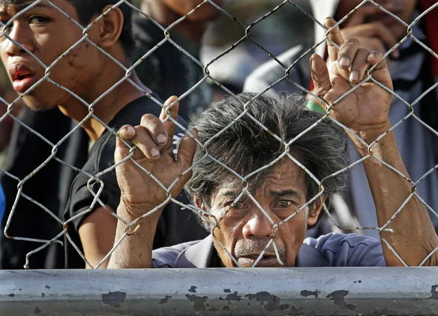 Residents queue up to receive treatment and relief supplies at Tacloban airport Monday November 11, 2013, following Friday's typhoon Haiyan that lashed this city and several provinces in central Philippines. (Photo by Bullit Marquez/AP Photo)