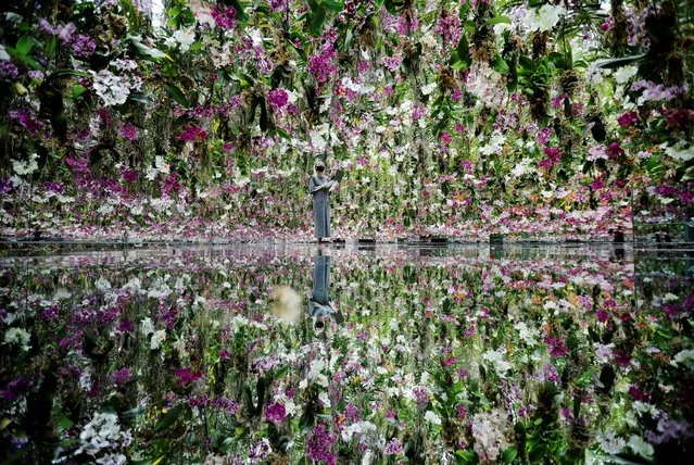 A teamLab staff member works inside the “Floating Flower Garden”, which consists of a three-dimensional mass of flowers, at teamLab Planets in Tokyo, Japan, June 3, 2021. (Photo by Kim Kyung-Hoon/Reuters)