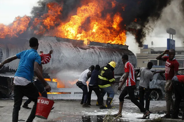 Firefighters try to contain a fire at a petrol station in Lagos, Nigeria on Thursday, March 26, 2015. (Photo by Sunday Alamba/AP Photo)