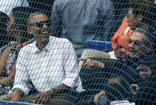 Cuban President Raul Castro, right, and U.S. President Barack Obama attend a baseball game between the Tampa Bay Rays and the Cuban national baseball team in Havana, Cuba, on March 22, 2016. The crowd roared as Obama and Castro entered the stadium and walked toward their seats in the VIP section behind home plate. It was the first game featuring an MLB team in Cuba since the Baltimore Orioles played in the country in 1999. (Photo by Ismael Francisco/Cubadebate via AP Photo)