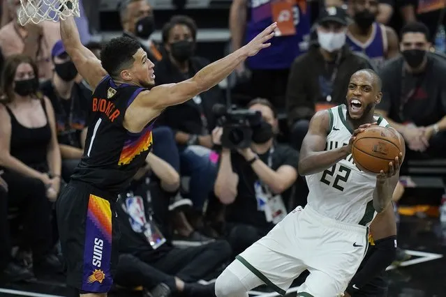 Milwaukee Bucks forward Khris Middleton (22) is defended by Phoenix Suns guard Devin Booker during the second half of Game 2 of basketball's NBA Finals, Thursday, July 8, 2021, in Phoenix. (Photo by Ross D. Franklin/AP Photo)