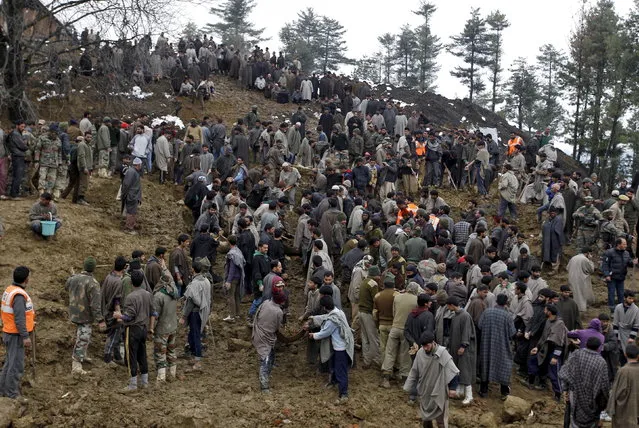Police and rescue workers search for bodies amongst the rubble after a hillside collapsed onto a house at Laden village, west of Srinagar, March 30, 2015. Local police superintendent Fayaz Ahmad Lone said six bodies had been recovered from the home in the village and the death toll was likely to rise further. (Photo by Danish Ismail/Reuters)