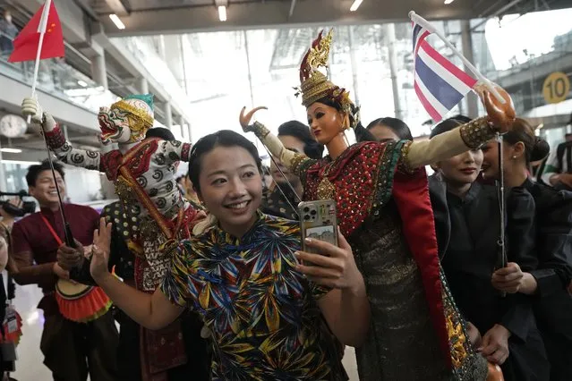 Chinese tourists dance with puppet as they are welcomed on arrivals at Suvarnabhumi International Airport in Samut Prakarn province, Thailand, Monday, September 25, 2023. Thailand's new government granting temporary visa-free entry to Chinese tourists, signaling that the recovery of the country's tourism industry is a top economic priority. (Photo by Sakchai Lalit/AP Photo)