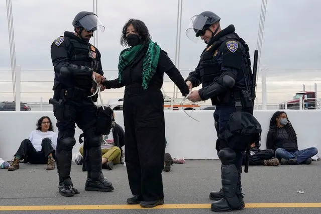 Security force members detain a person after demonstrators calling for a ceasefire in the ongoing conflict between Israel and the Palestinian Islamist group Hamas blocked the Bay Bridge, a key commuter route into the city which is hosting the Asia Pacific Economic Cooperation (APEC) CEO Summitin San Francisco, California on November 16, 2023. (Photo by Loren Elliott/Reuters)