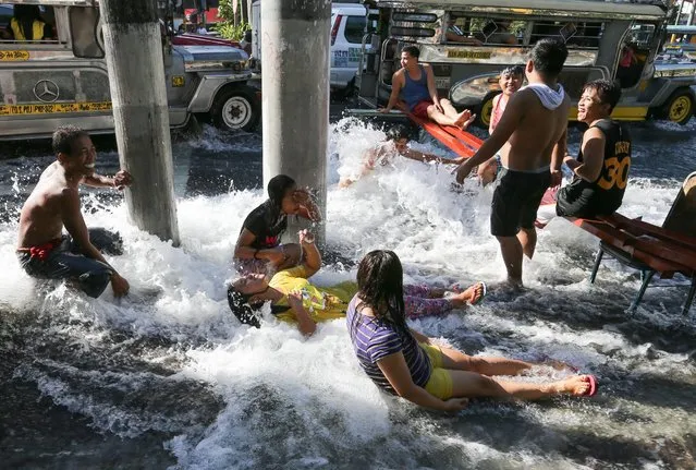 Filipinos frolic along flowing water after a water pipe broke down in Manila, Philippines, 11 February 2016. A water pipe that broke down on 10 February night caused floods and hampered transportation in Manila. Reports said authorites have already closed some service pipes but the water continues to flow which local residents took advantage of by collecting water. (Photo by Mark R. Cristino/EPA)