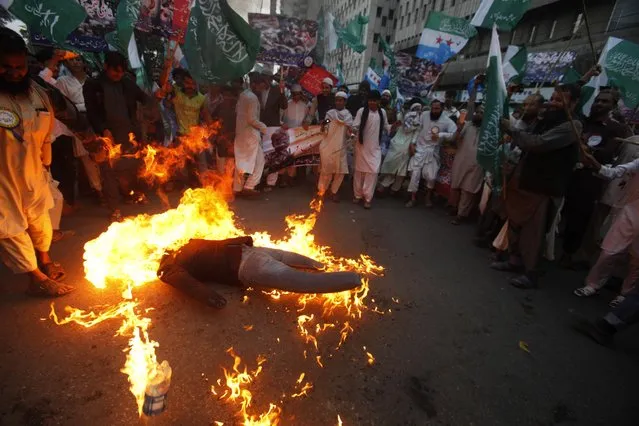 Supporters of Pakistani religious group burn an effigy of Syrian president Bashar Assad during a rally to condemn violence in Syria, in Karachi, Pakistan, Friday, January 6, 2017. (Photo by Fareed Khan/AP Photo)