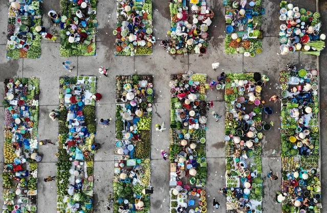 This aerial photo shows vendors selling vegetable at Vi Thanh market in Hau Giang province on October 25, 2023. (Photo by Nhac Nguyen/AFP Photo)