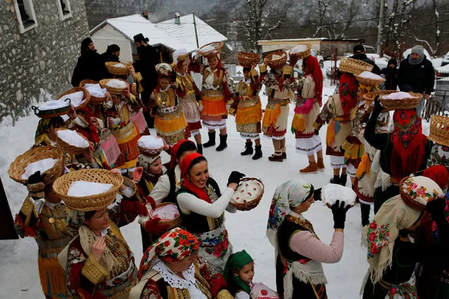 Women dressed in traditional folk costumes balance baskets of bread on their heads during an Epiphany day celebration in Bitushe village, Macedonia January 19, 2017. (Photo by Ognen Teofilovski/Reuters)