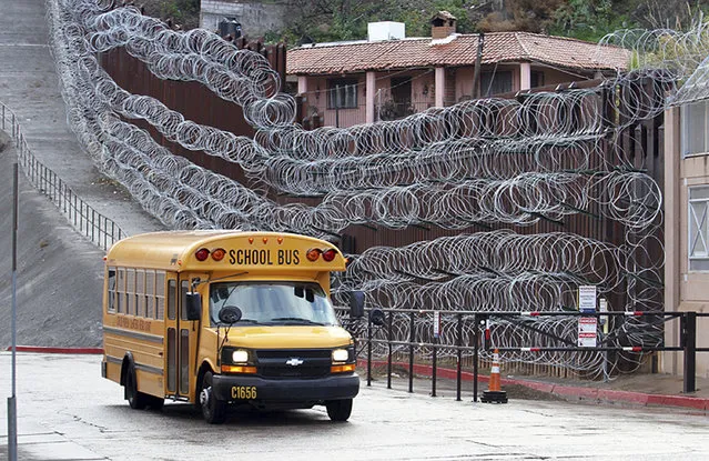 In this Monday, February 4, 2019 photo, a school bus rolls past the concertina wire-covered fence at East International and Nelson Streets in downtown Nogales, Ariz. The small Arizona border city is fighting back against the installation of razor fencing that now covers the entirety of a tall border fence along the city's downtown area. The city of Nogales, which sits on the border with Nogales, Mexico, is contemplating a proclamation Wednesday, Feb. 6, 2019, condemning the use of concertina wire in its town. (Photo by Jonathan Clark/Nogales International via AP Photo)
