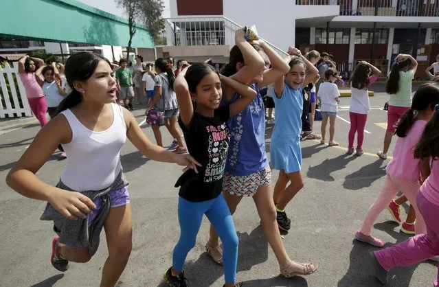 Students evacuate a class during a national earthquake evacuation drill at Franco Peruano school in Lima, April 22, 2015. The Ministry of Education of Peru conducted a nationwide earthquake and landslides drill to raise awareness of proper evacuation plans and prepare students in case of a disaster, according to local media. (Photo by Mariana Bazo/Reuters)