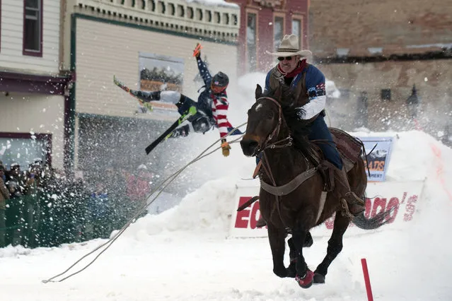 Jeff Dahl races down Harrison Avenue while skier Vincent Pestello looses control of the first jump of the Leadville ski joring course during the 71st annual Leadville Ski Joring weekend competition on March 2, 2019 in Leadville, Colorado. Skijoring, which has its origins as a competitive sport in Scandinavia, has been adapted over the years to include jumps, slalom gates, and spearing rings for points. Leadville has been hosting skijoring competitions since 1949. (Photo by Jason Connolly/AFP Photo)