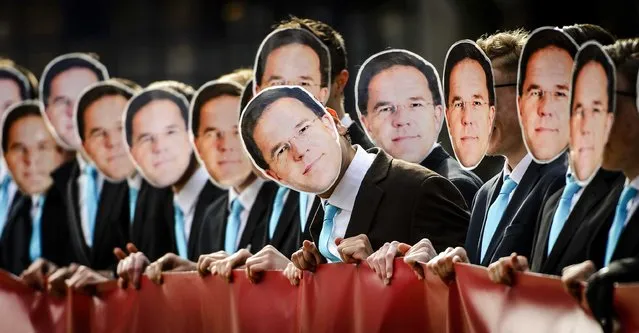 Demonstrators wear masks depicting Dutch Prime Minister Mark Rutte during a protest against the cloning of farm animals, in The Hague, The Netherlands, 08 March 2016. The activists offered a petition to the international animal welfare organization Compassion in World Farming with more than 10,000 signatures for a ban on cloning. (Photo by Remko de Waal/EPA)