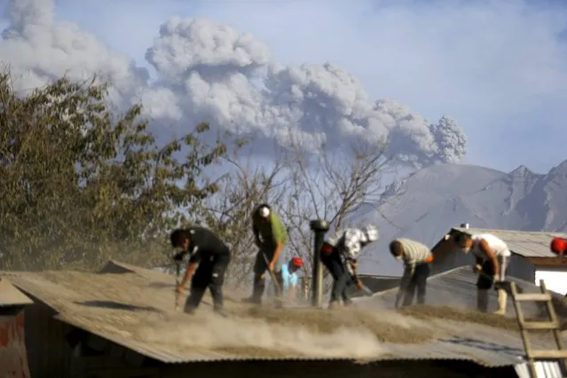 People clean an ash-covered roof of a house in Ensenada town, April 24, 2015. Chilean volcano Calbuco, which erupted without warning on Wednesday, is still puffing out ash and smoke, leading airlines to cancel flights from Argentine capital Buenos Aires, some 1,400 kilometers east. (Photo by Ivan Alvarado/Reuters)