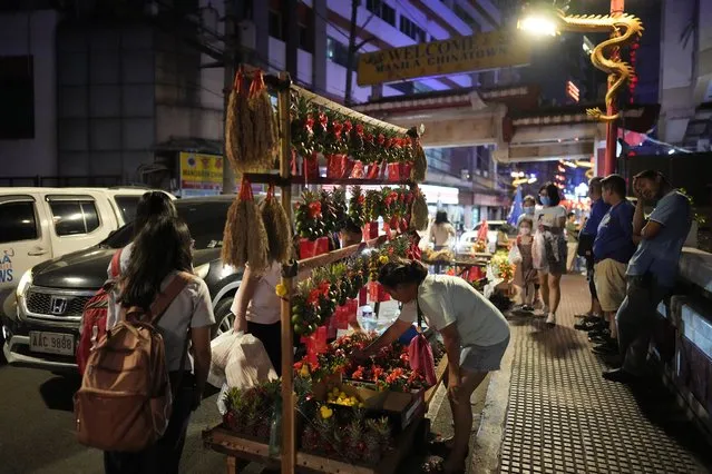 A vendor sells fruits with lucky charms for the coming Chinese New Year at Binondo district, said to be the oldest Chinatown in the world, in Manila, Philippines on Tuesday, February 6, 2024. (Photo by Aaron Favila/AP Photo)