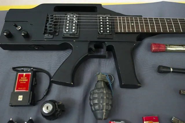 Items, prohibited on passenger airlines, and confiscated from passengers by Transportation Security Administration (TSA) officers, is displayed at Dulles International Airport in Dulles, Va., Tuesday, March 26, 2019. The items include a guitar shaped like a semi-automatic rifle, an inert grenade, and a stun gun. (Photo by Cliff Owen/AP Photo)