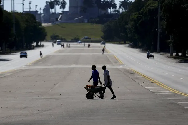 A man pushes a wheelbarrow as they cross an avenue of Havana city, Cuba, March 17, 2016. (Photo by Ivan Alvarado/Reuters)