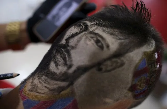Hair artist and barber Nariko, 27, etches an image of Barcelona's Neymar on the head of customer Luiz Fernadez, 15, before the Champions League semifinal first leg soccer match between Barcelona and Bayern Munich, at his barbershop in Sao Vicente, near Santos, in Sao Paulo state May 6, 2015. (Photo by Nacho Doce/Reuters)