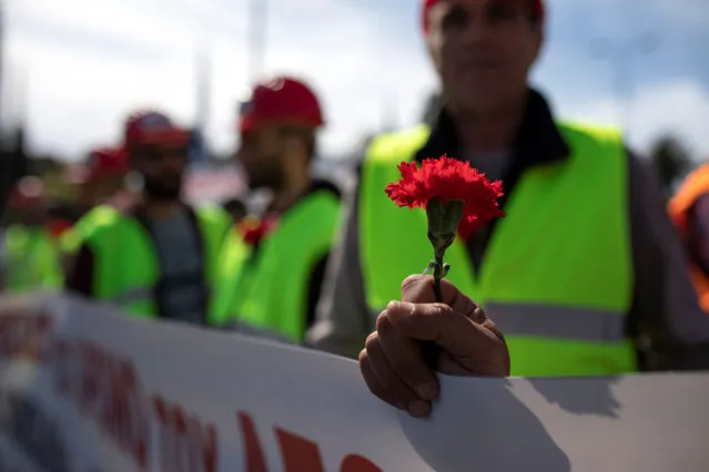 A member of the communist-affiliated PAME holds a carnation during a rally commemorating May Day in Athens, Greece, May 1, 2019. (Photo by Alkis Konstantinidis/Reuters)