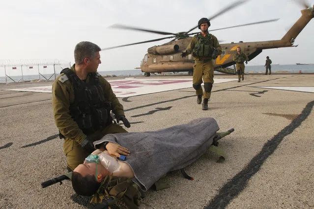 A wounded Israeli soldier is brought to a hospital in Haifa, Israel, Tuesday, March 18, 2014. A roadside bomb hit an Israeli patrol near the frontier with the Golan Heights on Tuesday, the army said, wounding four soldiers in the most serious violence to strike the area since the Syrian conflict began three years ago. (Photo by Hertzel Shapira/AP Photo)