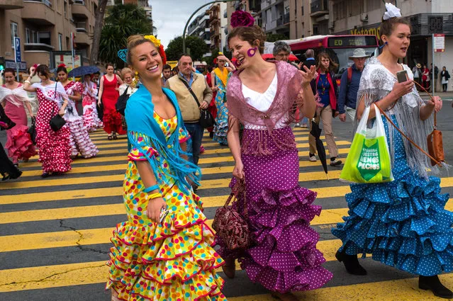 Women wearing traditional Sevillana dresses walk towards the Feria de Abril (April's Fair) on April 12, 2016 in Seville, Spain. The Feria de Abril, which has a history dating back to 1857, takes place a fortnight after Easter each year. The origin of the fair was a cattle market but the event quickly turned its goal from commerce to having fun. More than 1 million local and international participants are expected to attend to Feria de Abril. (Photo by David Ramos/Getty Images)
