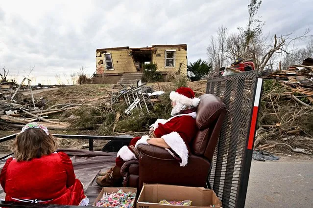Steely Vanlue, dressed as Mrs. Claus, and Troy Black, dressed as Santa Claus, pass by a destroyed home on Christmas Eve in a heavily damaged neighborhood after tornadoes ripped through several U.S. states in Dawson Springs, Kentucky, U.S., December 24, 2021. (Photo by Jon Cherry/Reuters)