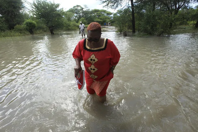 Former Zimbabwean Deputy Prime Minister Thokozani Khupe crosses a flooded road on her way to assess damages caused by floods in Tsholostho about 200 kilometres north of Bulawayo, Saturday, March 4, 2017. Zimbabwe says floods have killed over 200 people and left close to 2,000 homeless since December. The Southern African country has appealed to International donors for $100 million to help those affected by floods. (Photo by Tsvangirayi Mukwazhi/AP Photo)