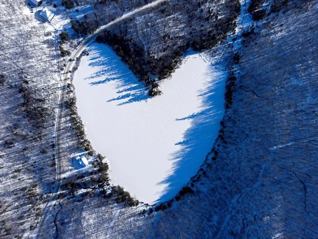 Snow covers the heart-shaped and frozen Baker Pond on Christmas Eve in East Bolton, Quebec, Canada on December 24, 2021. Picture taken with a drone. (Photo by Bernard Brault/Reuters)