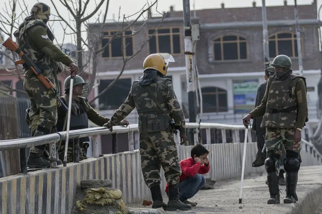In this March 29, 2017, file photo, Indian paramilitary soldiers force a Kashmiri child to perform sit-up while holding his ear lobes, a common elementary school punishment in India, before letting him go during a strike in Srinagar, Indian-controlled Kashmir. Seeing Kashmiri residents doing calisthenics on the side of the road was once common in the 1990s, as government forces sought to humiliate people as a way of dissuading any support for armed rebels fighting against Indian rule in the disputed Himalayan territory. As the rebellion was crushed, Indian soldiers mostly stopped using public sit-ups as a form of punishment. (Photo by Dar Yasin/AP Photo)