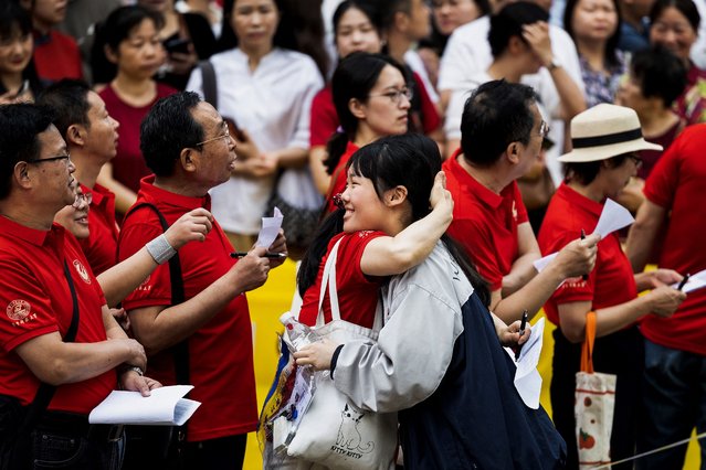 A student hugs a teacher outside a school on the first day of the national college entrance examination, known as “Gaokao”, in Wuhan, in central China's Hubei province on June 7, 2024. (Photo by AFP Photo/China Stringer Network)