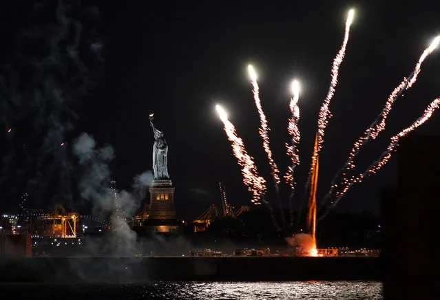 Fireworks launched from a barge explode over New York Harbor and the Statue of Liberty as New York and other cities around New York state recognize a rate of 70% for single dose vaccinations against the COVID-19 virus, Tuesday, June 15, 2021 in New York. Celebration of the milestone was announced by Gov. Andrew Cuomo earlier in the day. (Photo by Craig Ruttle/AP Photo)