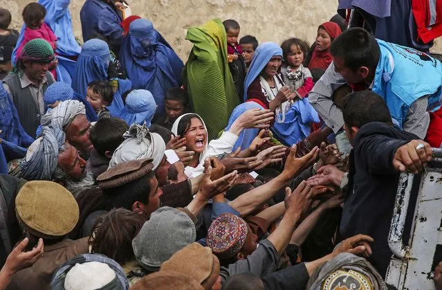 Survivors try to get some donations near the site of Friday's landslide that buried Abi Barik village in Badakhshan province, northeastern Afghanistan, on May 5, 2014. As Afghans observed a day of mourning Sunday for the hundreds of people killed in a horrific landslide, authorities tried to help the 700 families displaced by the torrent of mud that swept through their village. (Photo by Massoud Hossaini/Associated Press)